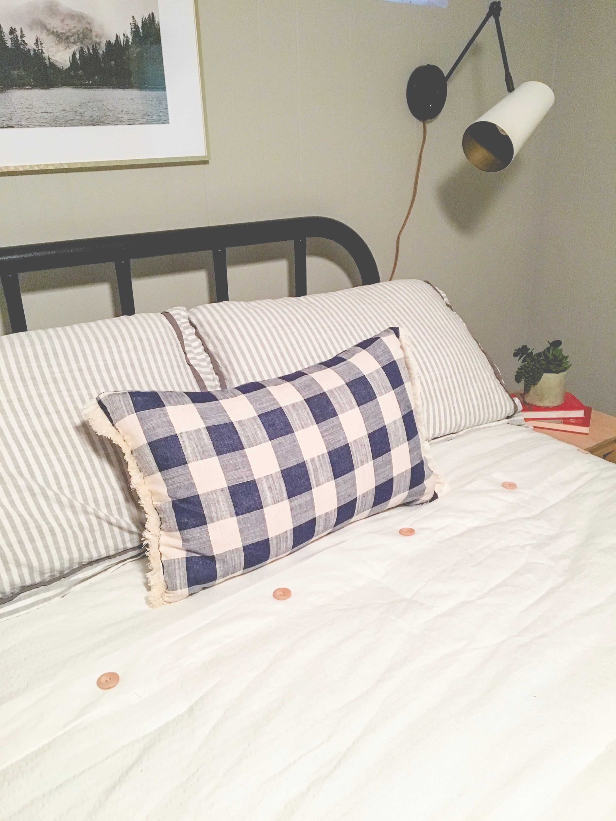 Our boring guest room gets a whole new modern cozy chic cabin look! Learn how to redecorate your guest room so it feels cozy and welcoming. A plaid lumbar pillow is the perfect finishing touch.