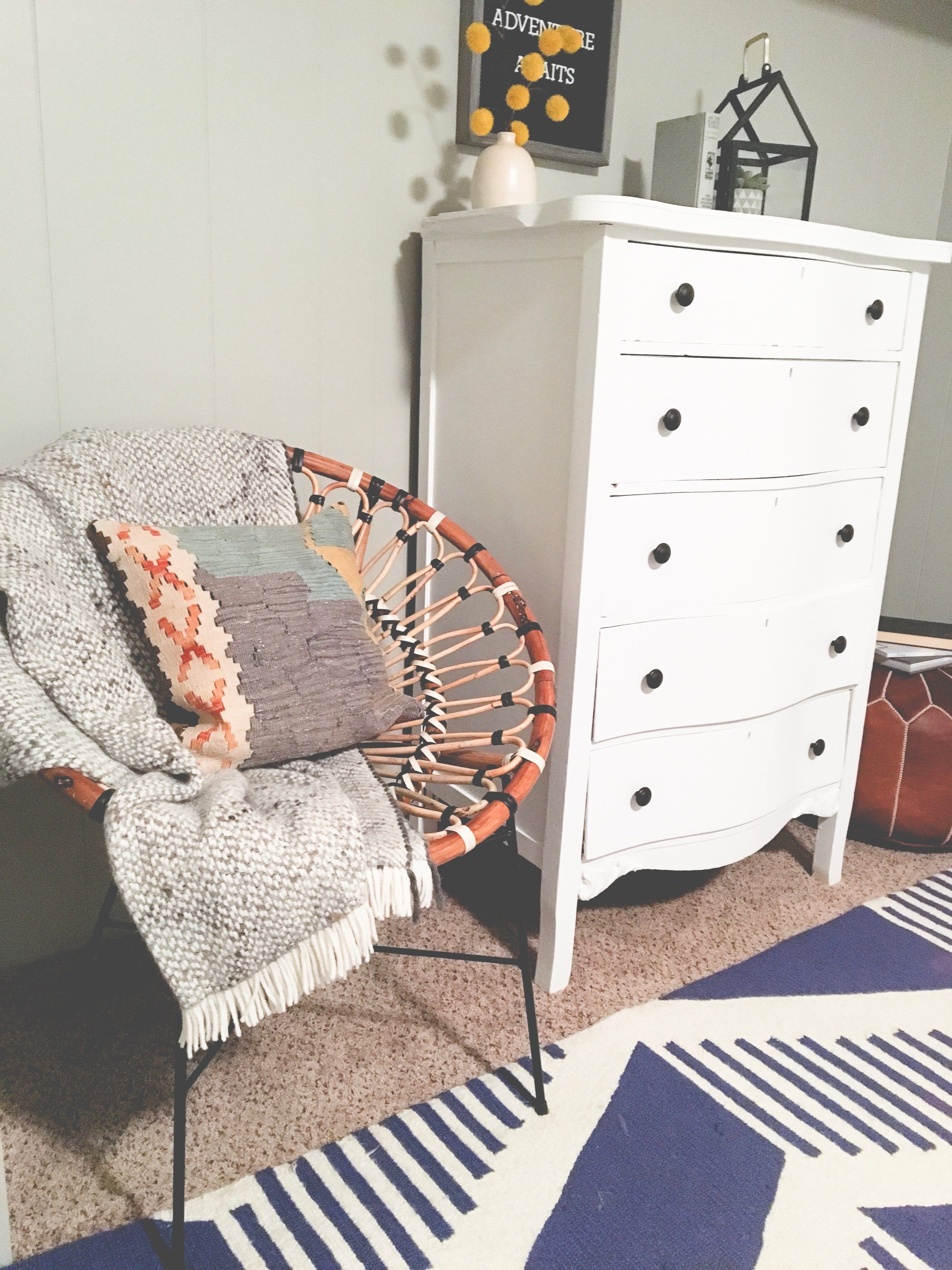 Our boring guest room gets a whole new modern cozy chic cabin look! Learn how to redecorate your guest room so it feels cozy and welcoming. Create a little reading nook with this cute rattan chair.